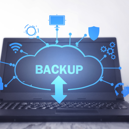 An open laptop on a table. On the screen a cloud with the word 'backup' is popping off the screen along with icons for wifi, security, automation and more.