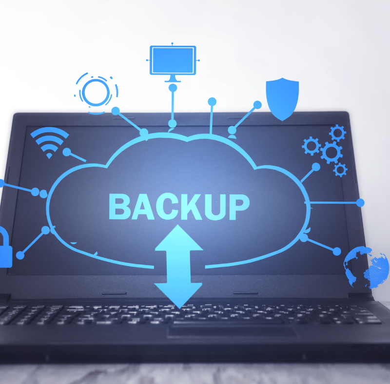 An open laptop on a table. On the screen a cloud with the word 'backup' is popping off the screen along with icons for wifi, security, automation and more.