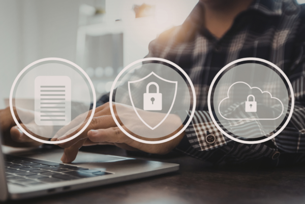A person typing on a laptop with three logos on top of the image: a document, a padlock on a shield, and a padlock on a cloud.