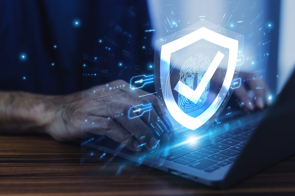 Man working on a laptop with advanced cyber security shield. cybersecurity resilience concept.