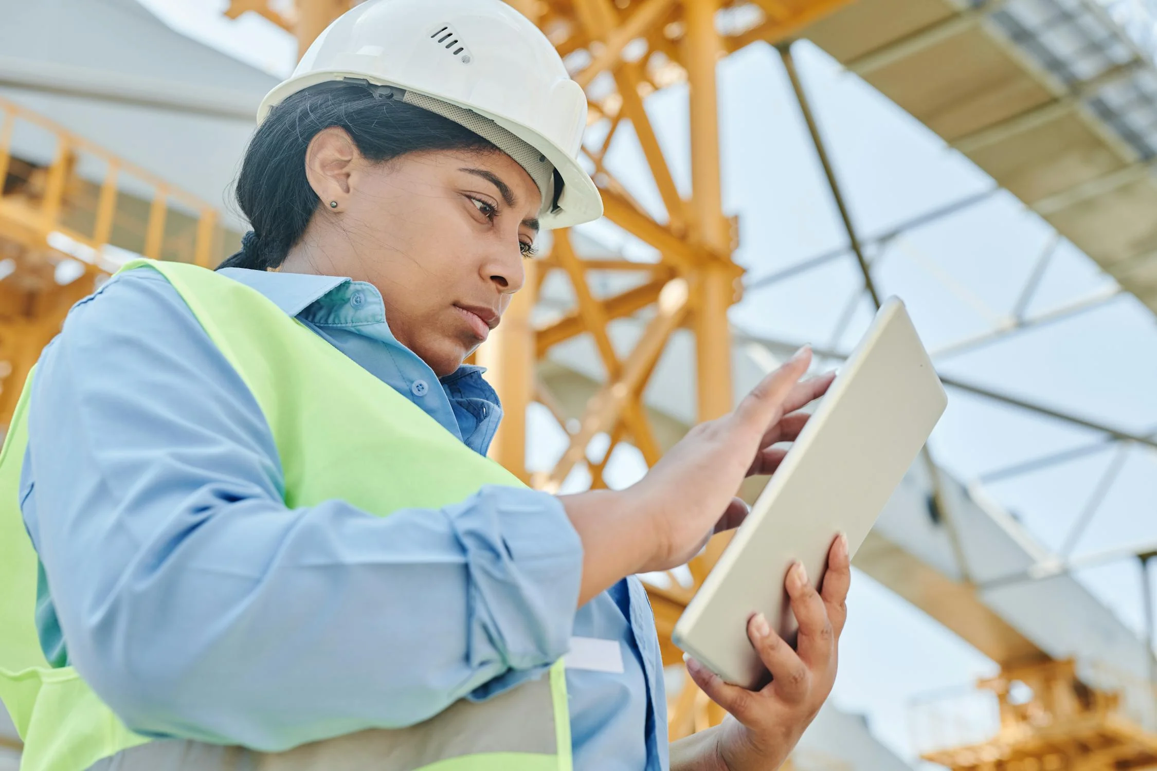 A construction worker uses a tablet to automate tasks on-site.
