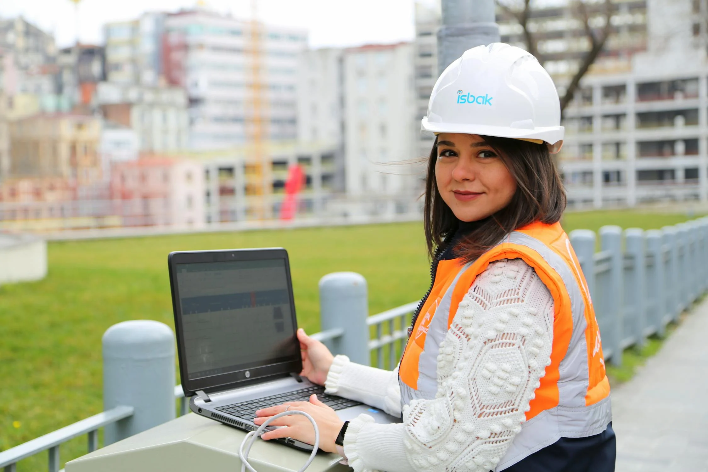 A female engineer uses a laptop on-site, leveraging business process automation to streamline a construction project.