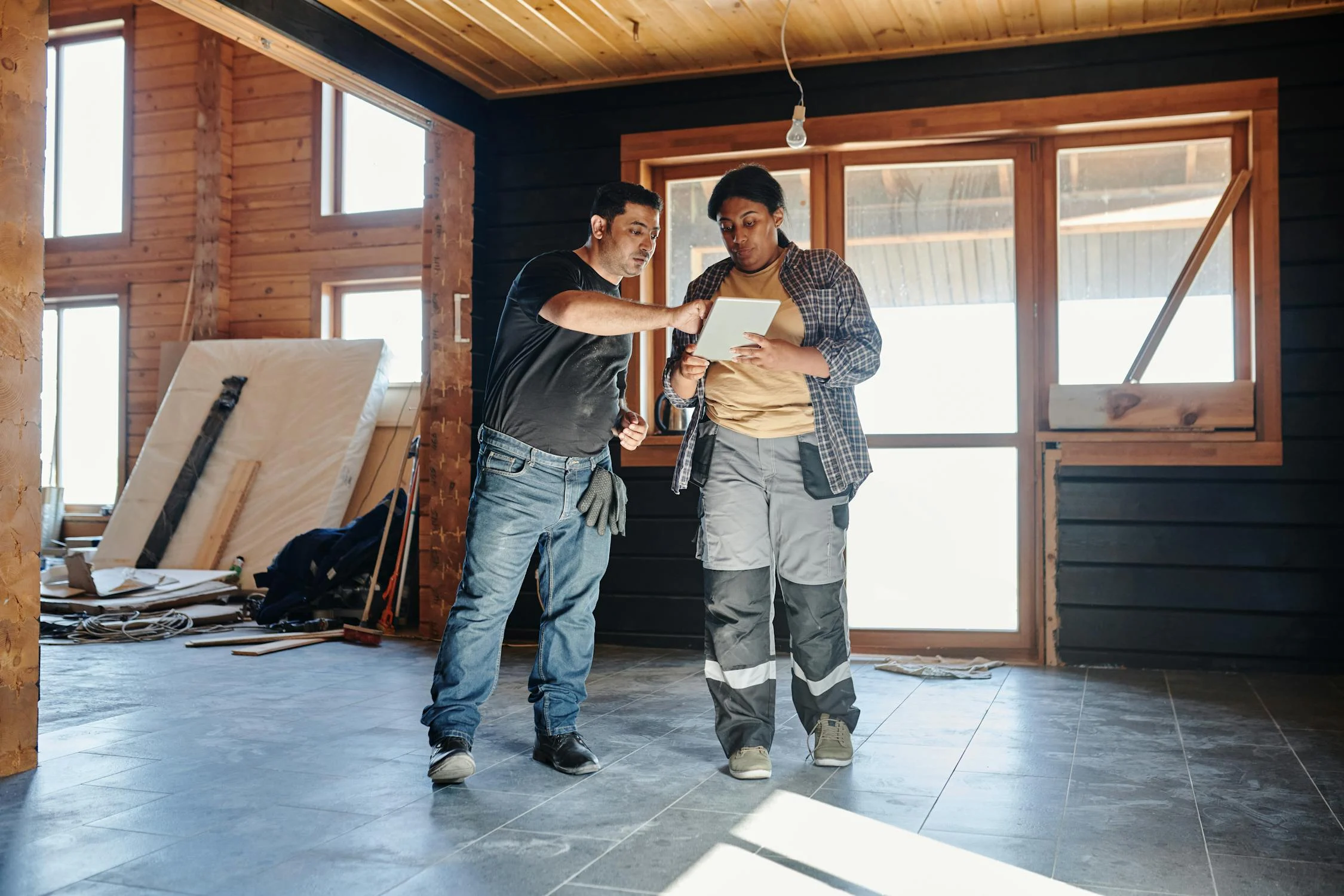 Two construction workers review site details on a tablet, demonstrating the role of intelligent content capture in replacing paper-based workflows with real-time digital data.