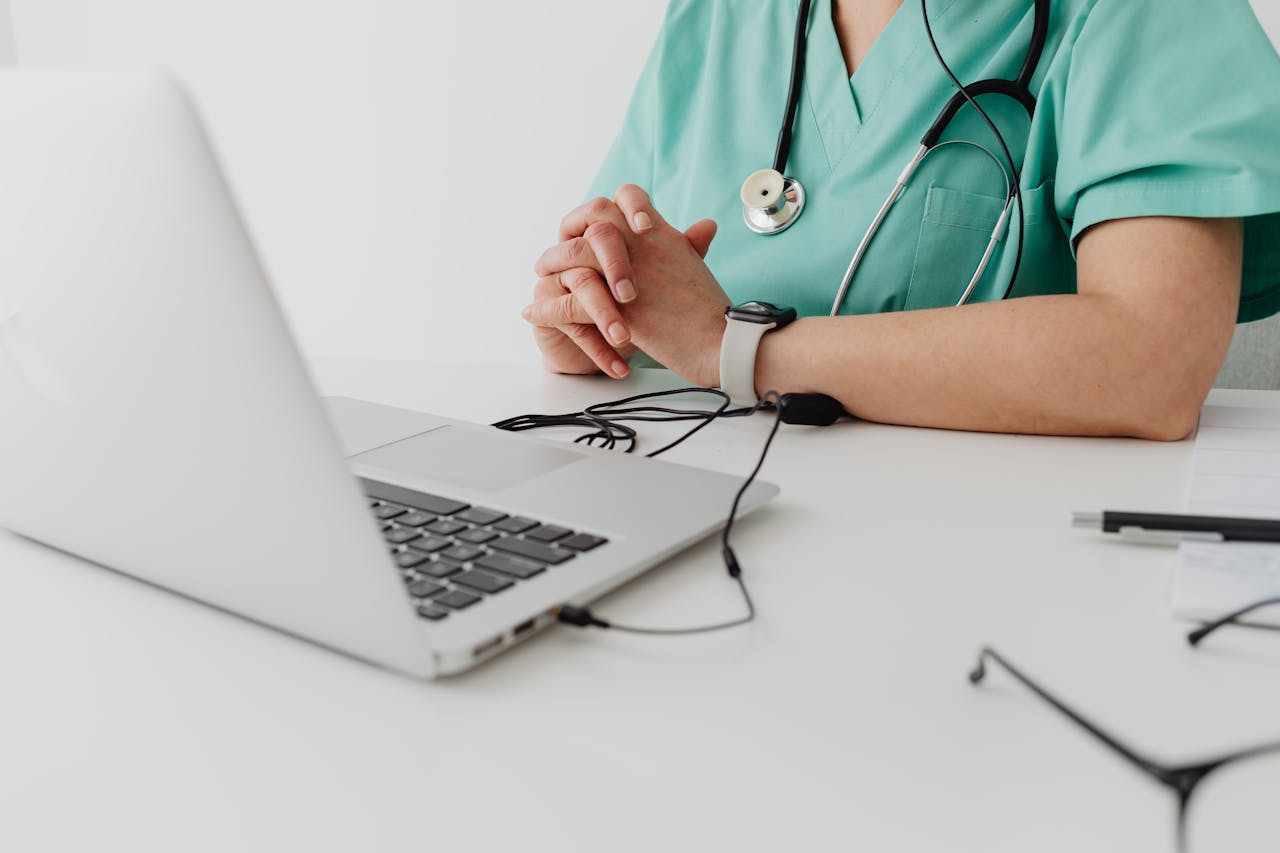 A medical professional uses a laptop with connected devices, showcasing the integration of healthcare and IT systems.