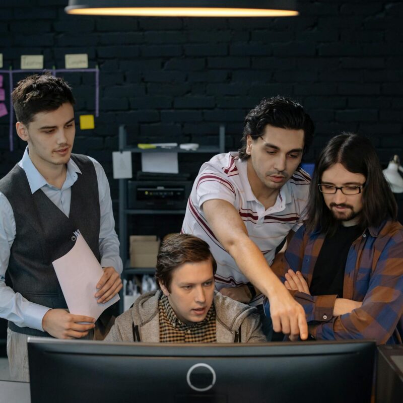 Employees collaborating on cybersecurity tasks as part of a company’s Cybersecurity Awareness Month initiatives.
