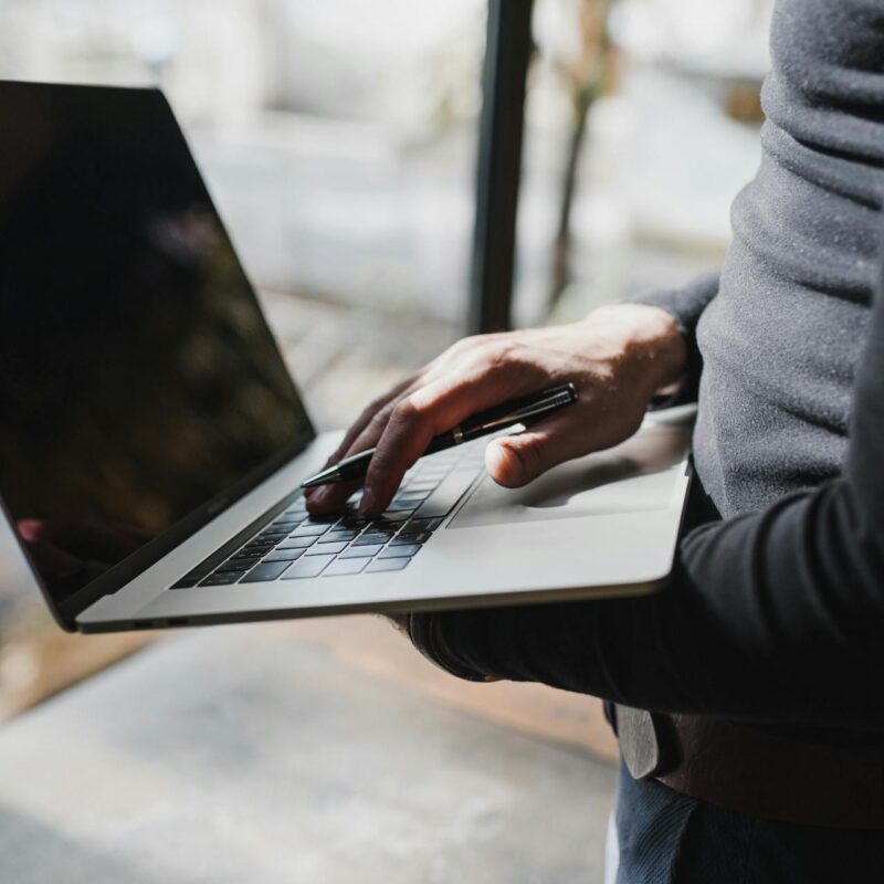 Person using a laptop to review reports generated with Microsoft AI tools for business.