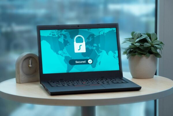 Laptop on round table with documents, symbolizing cyber risk review and insurance analysis