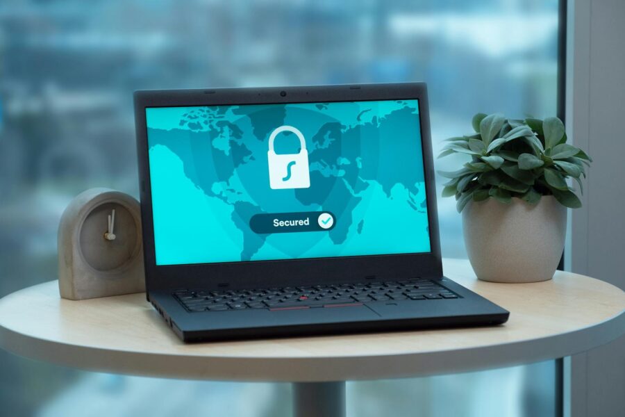 Laptop on round table with documents, symbolizing cyber risk review and insurance analysis