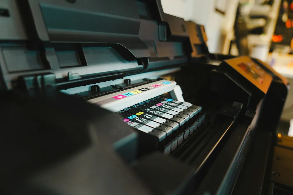 Close-up of printer ink cartridges being managed and monitored, representing how Managed Print Services ensure proper supply levels and prevent costly printing disruptions.