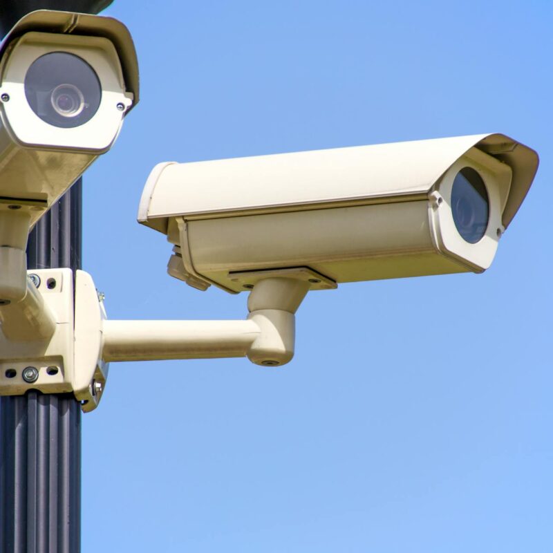 Two security cameras mounted on a pole, showing a video surveillance system used for monitoring and security.