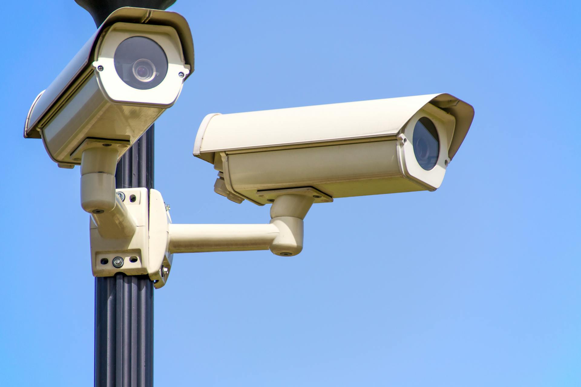 Two security cameras mounted on a pole, showing a video surveillance system used for monitoring and security.