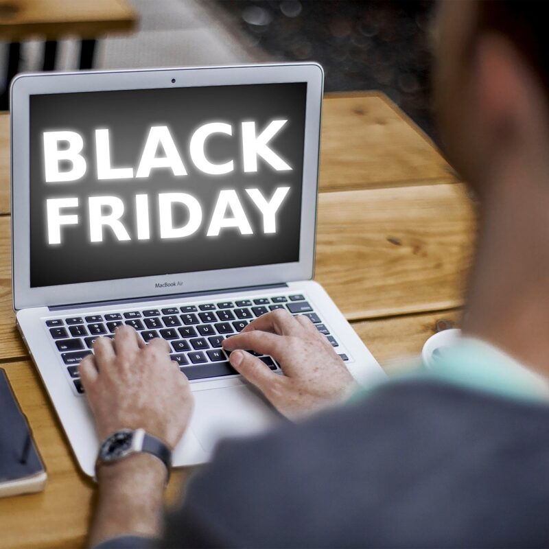 A person using a laptop displaying 'Black Friday,' symbolizing preparing a print fleet for high-volume holiday printing.