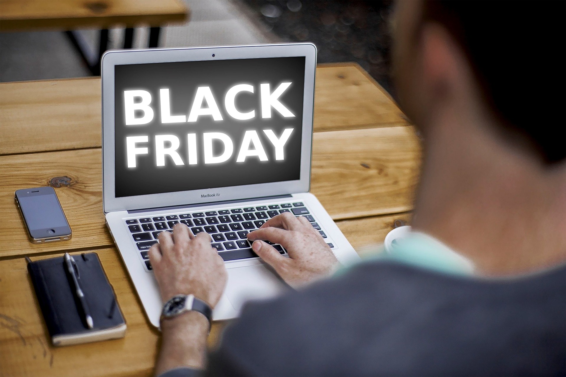 A person using a laptop displaying 'Black Friday,' symbolizing preparing a print fleet for high-volume holiday printing.