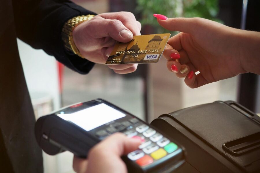 Person handing over a credit card at a payment terminal.