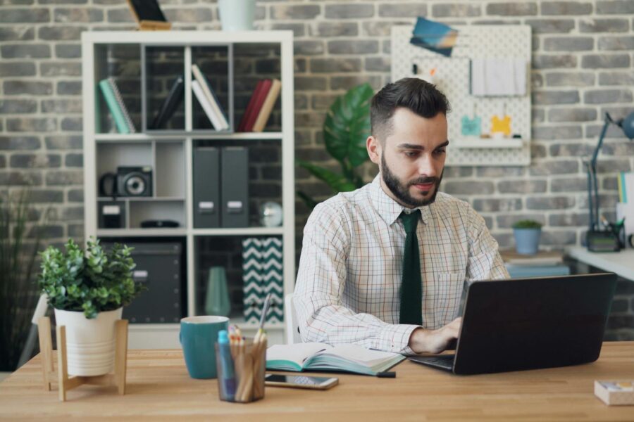 A professional uses AI-powered business tools on his laptop to streamline workflow and boost productivity.