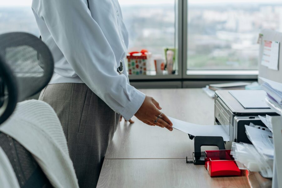 Person using an office printer, emphasizing secure handling of sensitive documents during printing.