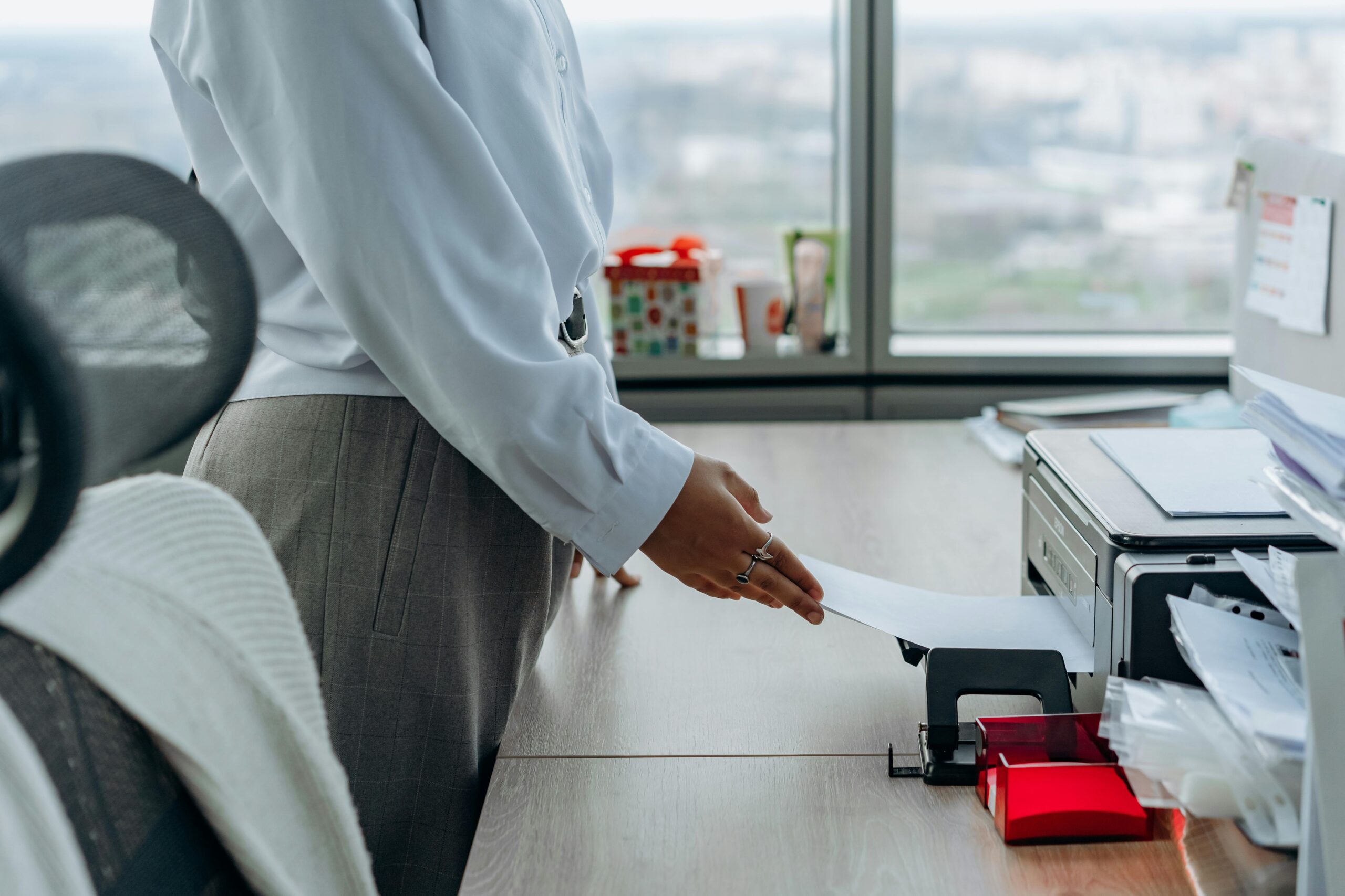 Person using an office printer, emphasizing secure handling of sensitive documents during printing.