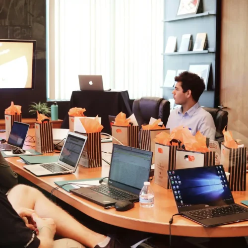 Team collaborating in a modern conference room with laptops, shared display, and hybrid meeting setup enabled by conference room technology.