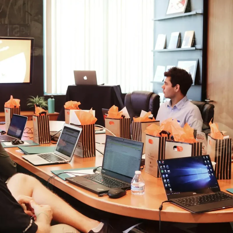 Team collaborating in a modern conference room with laptops, shared display, and hybrid meeting setup enabled by conference room technology.