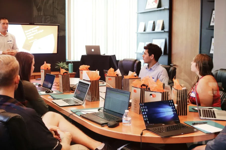 Team collaborating in a modern conference room with laptops, shared display, and hybrid meeting setup enabled by conference room technology.
