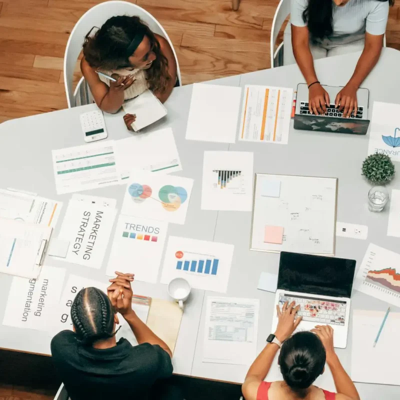Marketing team collaborates over data-driven campaign assets and charts, leveraging AI marketing insights to plan and optimize strategy.