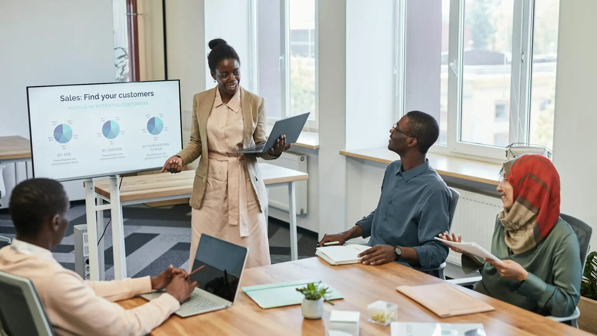 A presenter leads a data-driven pitch meeting, using AI tools to visualize customer demographics on a digital display.