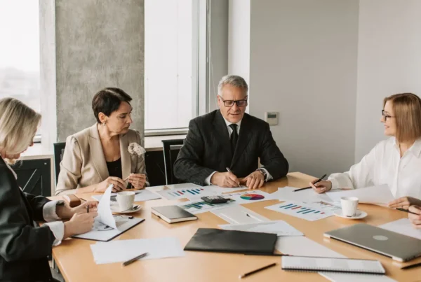A business execution strategy meeting where executives collaborate over performance charts and reports.