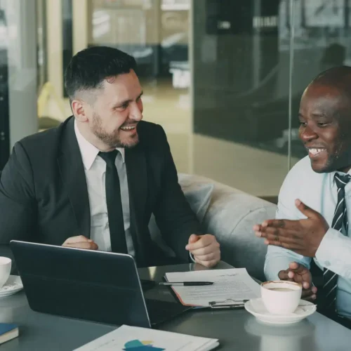 Two business professionals discuss contract terms to streamline operations through vendor consolidation.