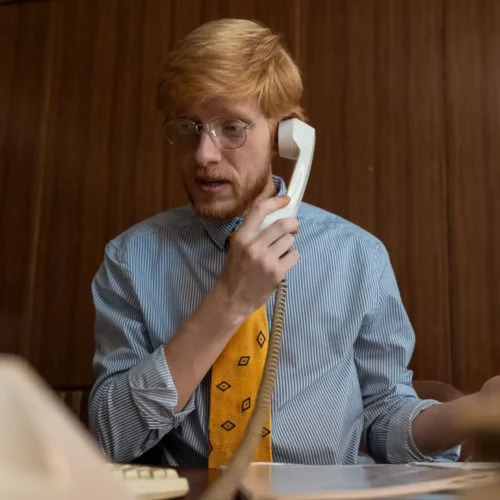 An office employee handling a suspected call spoofing attack on a desk phone.