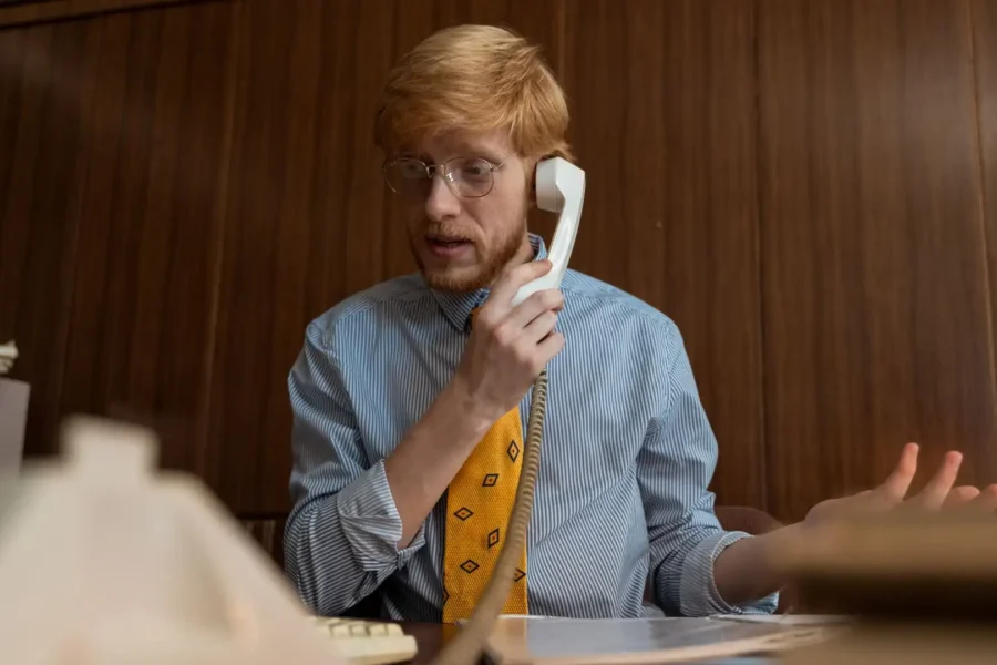 An office employee handling a suspected call spoofing attack on a desk phone.