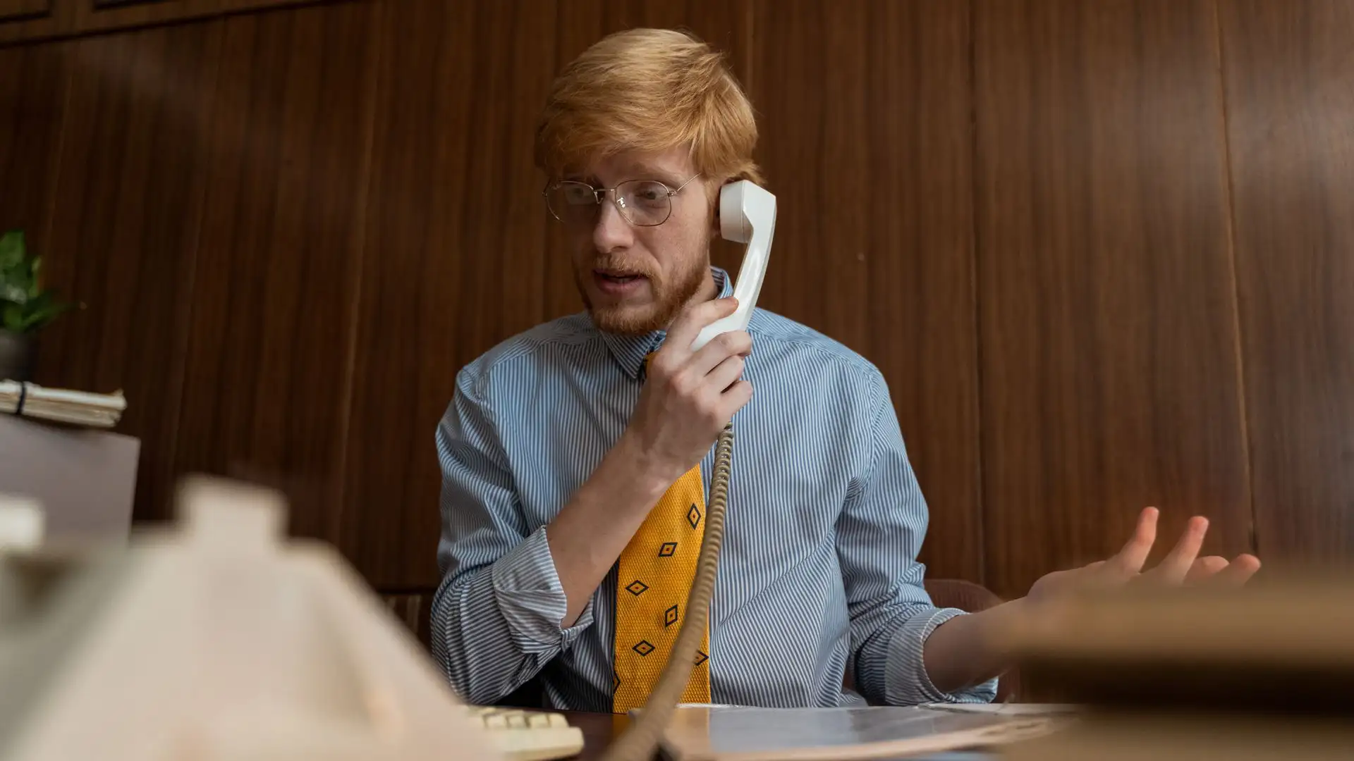 An office employee handling a suspected call spoofing attack on a desk phone.