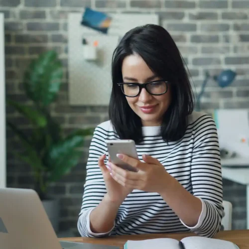 An employee using a smartphone for business texting in an office setting.