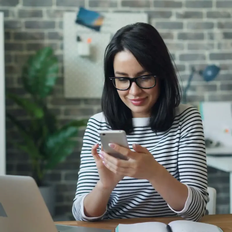 An employee using a smartphone for business texting in an office setting.