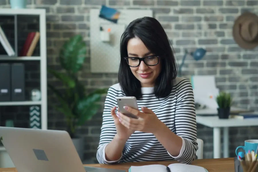 An employee using a smartphone for business texting in an office setting.