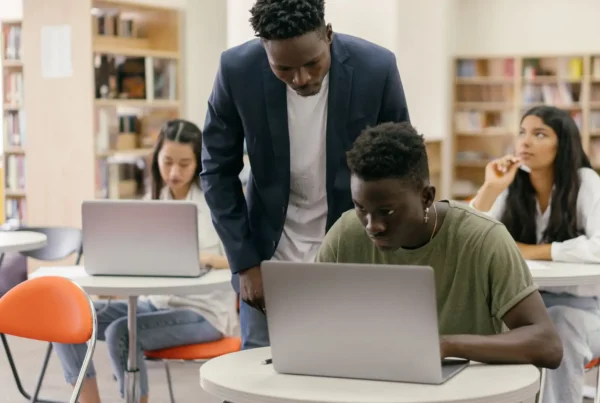 An educator oversees students, illustrating the human-led approach required by the Illinois AI guidelines for schools.