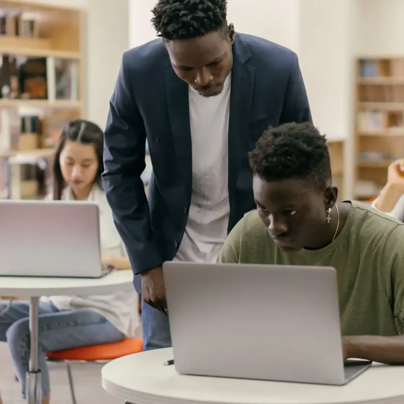 An educator oversees students, illustrating the human-led approach required by the Illinois AI guidelines for schools.