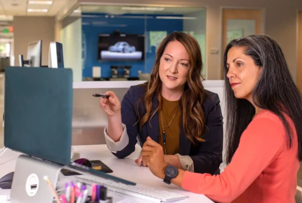 Two employees are analyzing SharePoint permissions that have grown overly complicated.