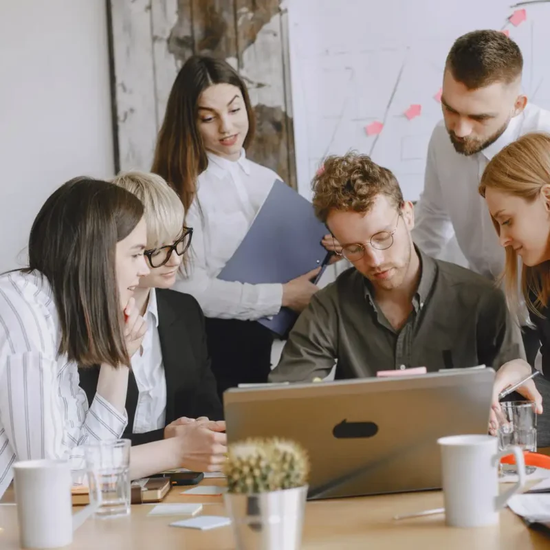 A team collaborates around a laptop to plan secure automation with Microsoft 365 processes.