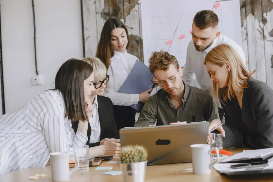 A team collaborates around a laptop to plan secure automation with Microsoft 365 processes.