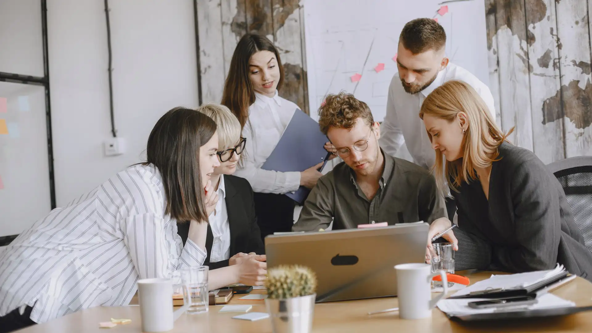 A team collaborates around a laptop to plan secure automation with Microsoft 365 processes.